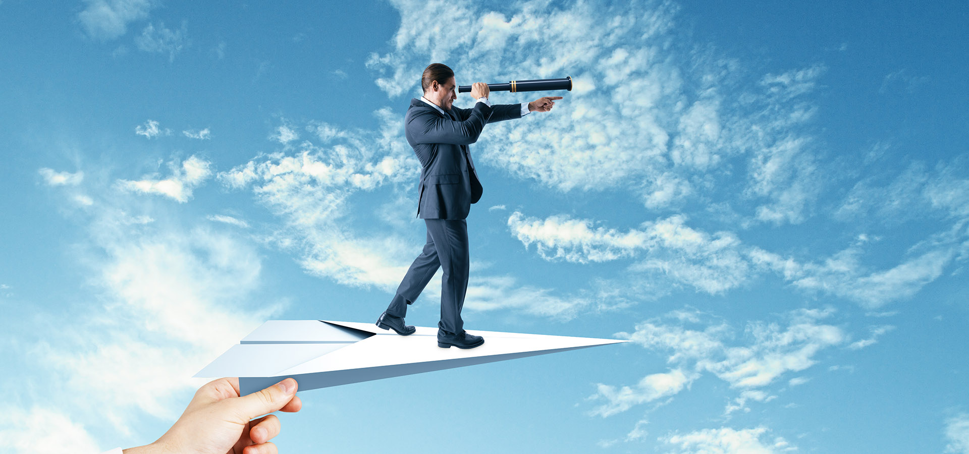 Le bilan de situation pour une vision élargie Montage photo : un homme en costume et chapeau melon regardant dans une longue-vu, debout sur un avion en papier. Concept du bilan de situation