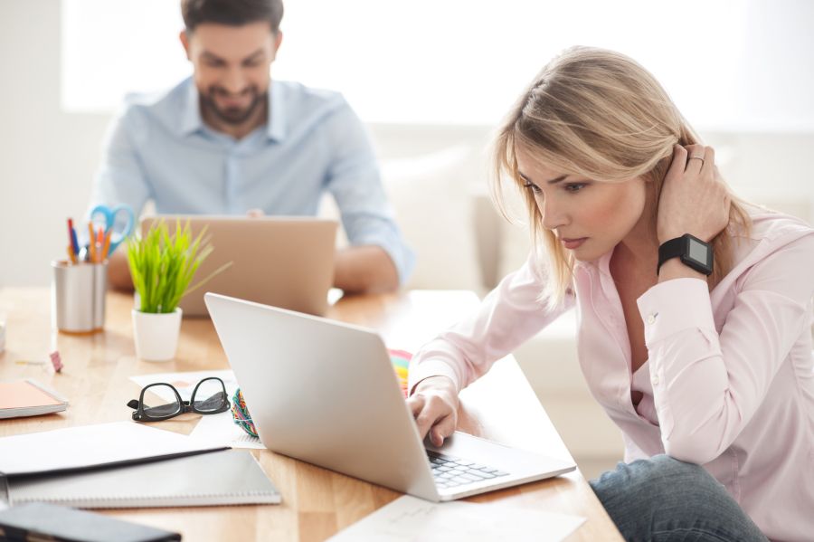 Un dirigeant a délégué du travail à une collaboratrice assise près de lui pour diminuer sa surcharge de travail.